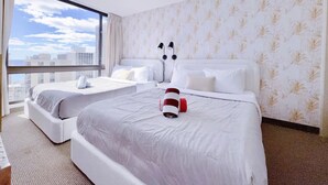 Ein Hotelzimmer mit zwei Betten, einem großen Fenster und Blick auf die Stadt.