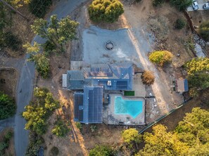 A residential property with a swimming pool, solar panels, and a fenced yard.