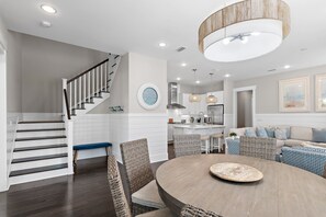 Un intérieur moderne comprenant un escalier, un coin repas et une cuisine.