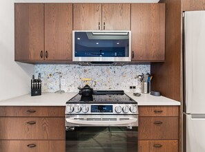 A kitchen with wooden cabinets, a stainless steel range, a microwave, and a built-in oven. - Cute Updated 1BR Condo in Park City, 30 Night Min (Park City)