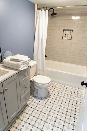 Ein Badezimmer mit Toilette, Badewanne und Duschvorhang.