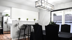 A modern kitchen with a dining area, featuring a built-in refrigerator, a dining table with chairs, and a pendant light. - Serene Tuxedo 3-bedroom townhome with AC in charming Grandview (Grandview)