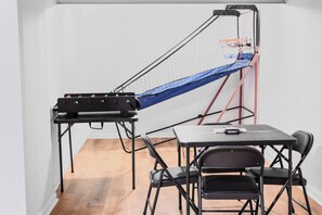 Ein Zimmer mit einem Tisch, zwei Stühlen, einem kleinen Tisch mit einem Gerät und einem großen Trainingsgerät.