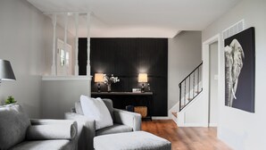 A modern living room with a grey sofa set, a coffee table, and a staircase leading to an upper floor. - Serene Tuxedo 3-bedroom townhome with AC in charming Grandview (Grandview)
