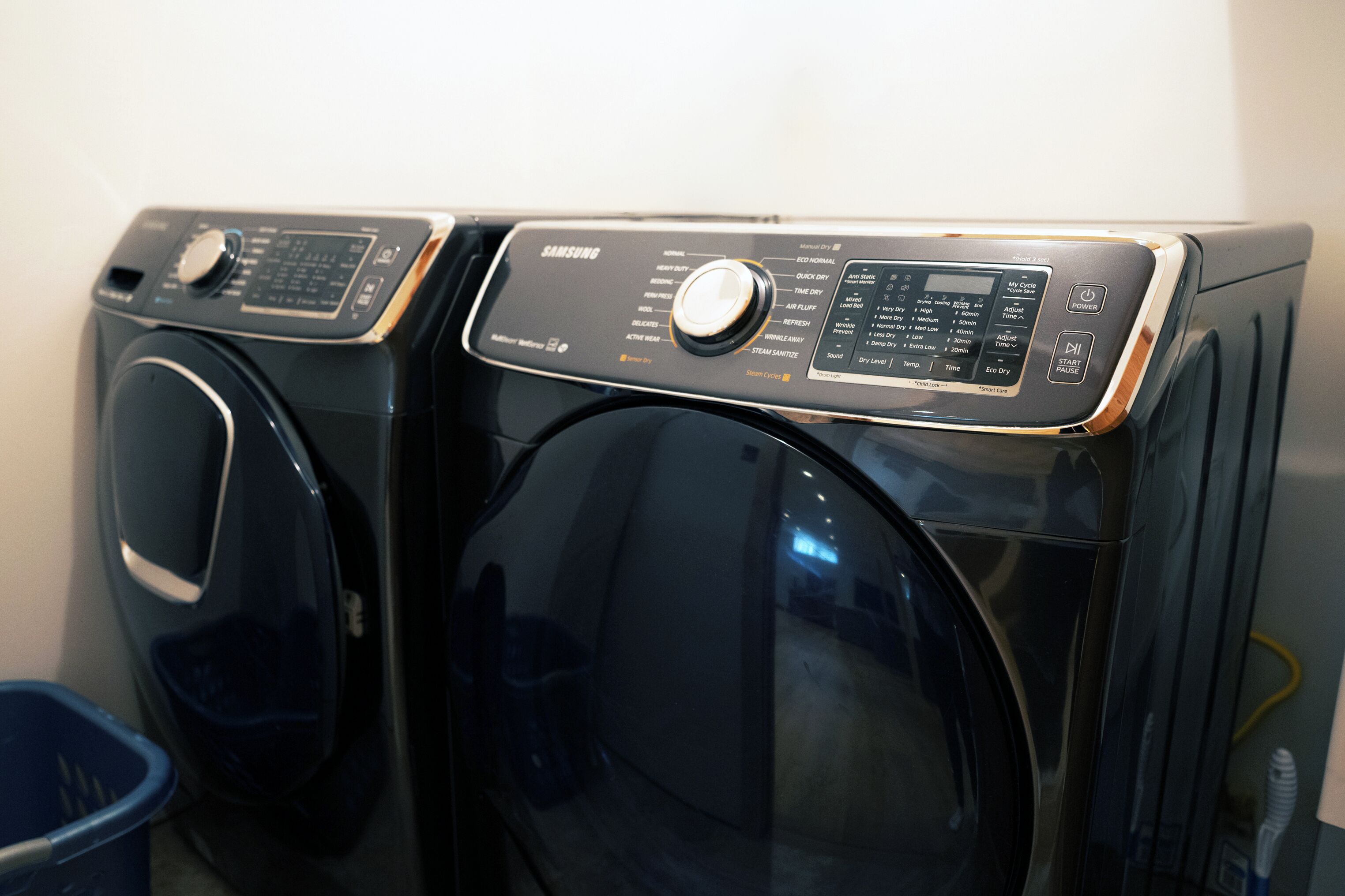 Vue de face d’un lave-linge noir à chargement frontal, doté d’un panneau de commande et d’un écran numérique.
