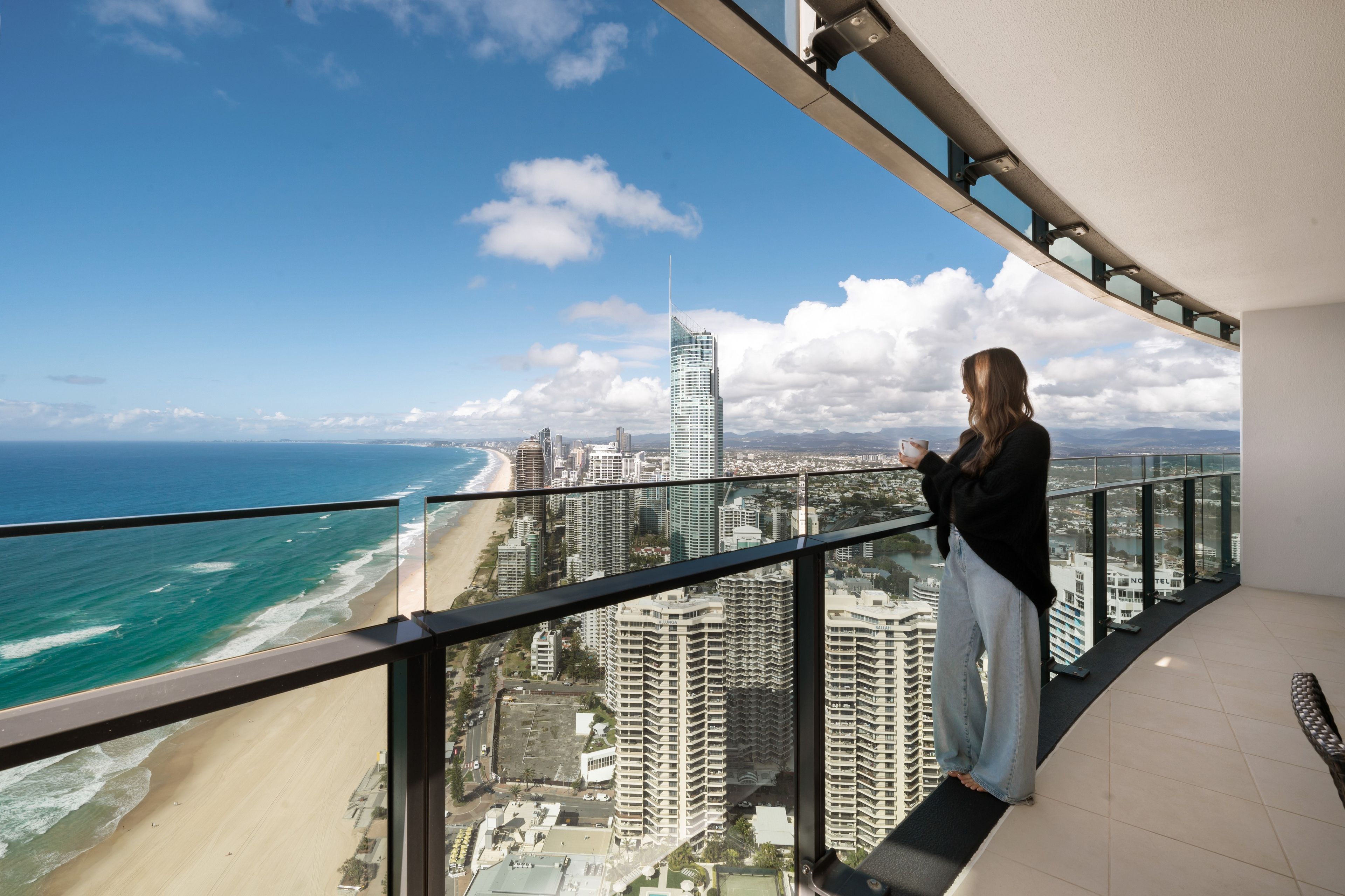 Ein Balkon mit Blick auf Strand und Stadtbild.