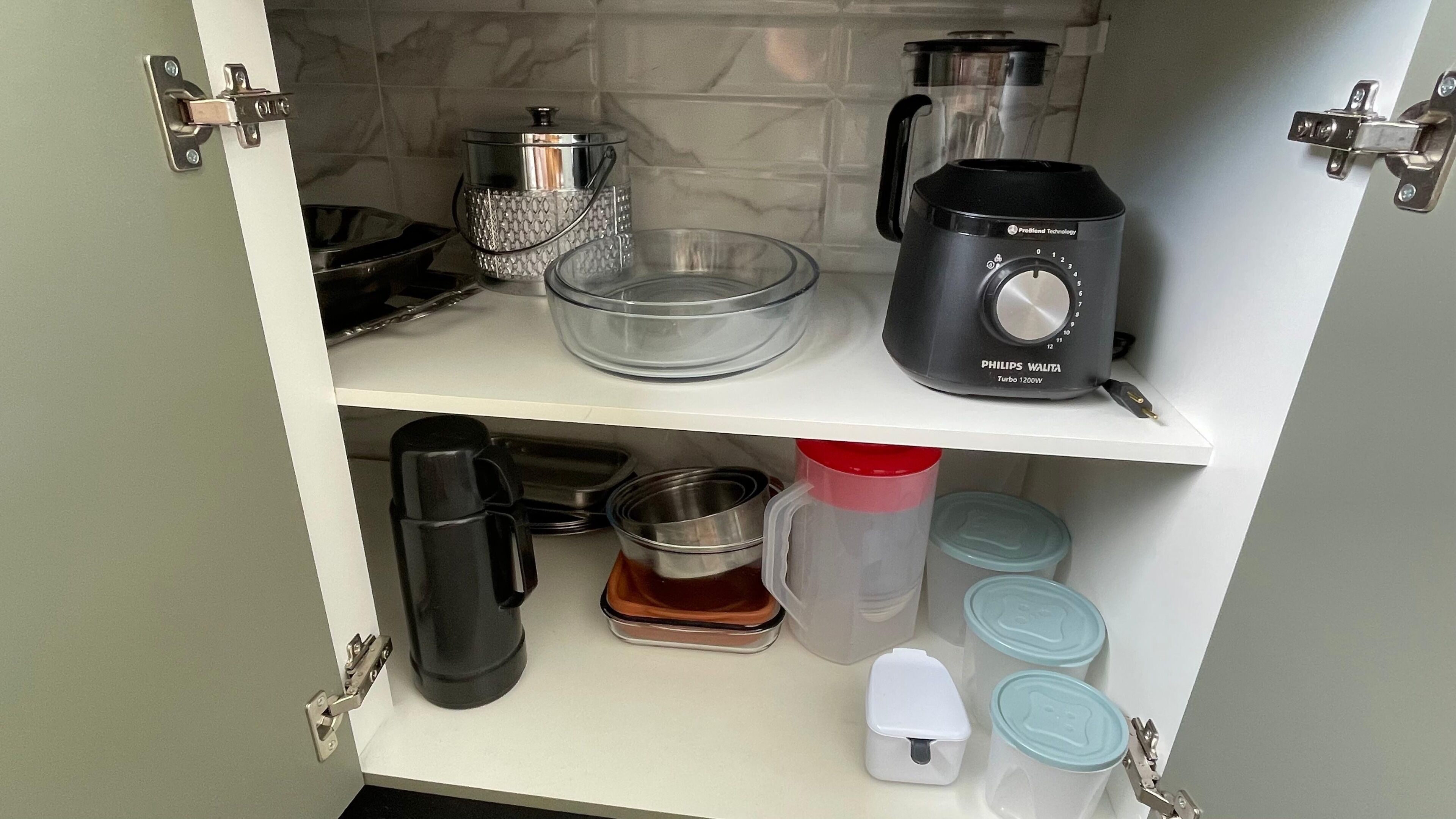 Cozinha com cafeteira, liquidificador e diversos recipientes nas prateleiras.