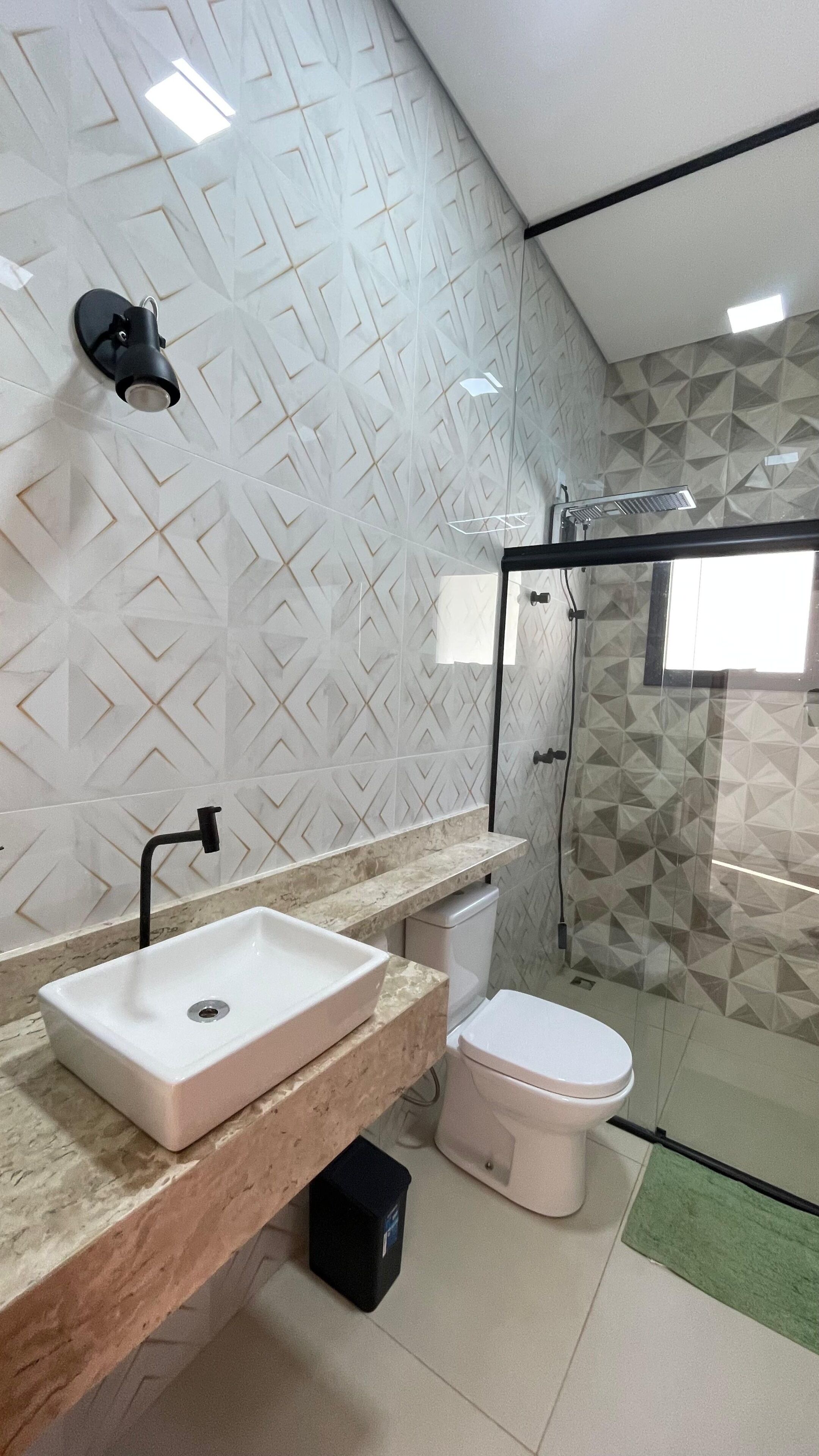 Un baño con lavamanos blanco, inodoro y zona de ducha.