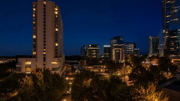 A nighttime cityscape with modern buildings, including a prominent high-rise hotel and several other commercial structures.