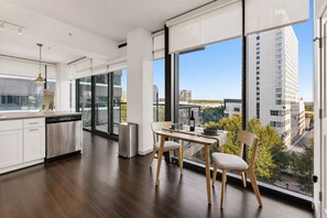 Eine moderne Küche mit Essbereich, großen Fenstern und Blick auf die Stadtlandschaft.