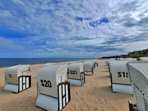 Beachside hotel rooms with numbers on the doors, arranged in rows facing the ocean. - Villa Waldstrasse 03 (Heringsdorf)