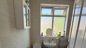 Un baño pequeño con inodoro, lavabo y ventana.