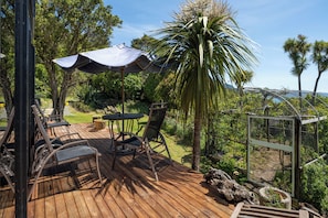 Eine Holzterrasse mit Gartenmöbeln, einem Tisch und Stühlen.