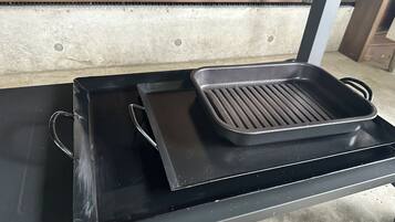 Una bandeja negra sobre una mesa con una plancha metálica encima.