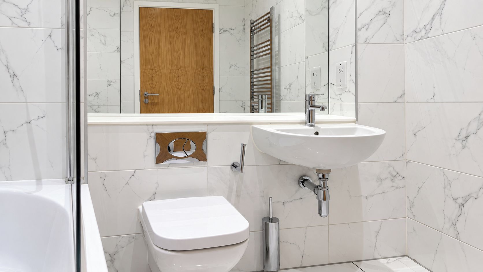 A bathroom with a toilet, a sink, and a mirror.
