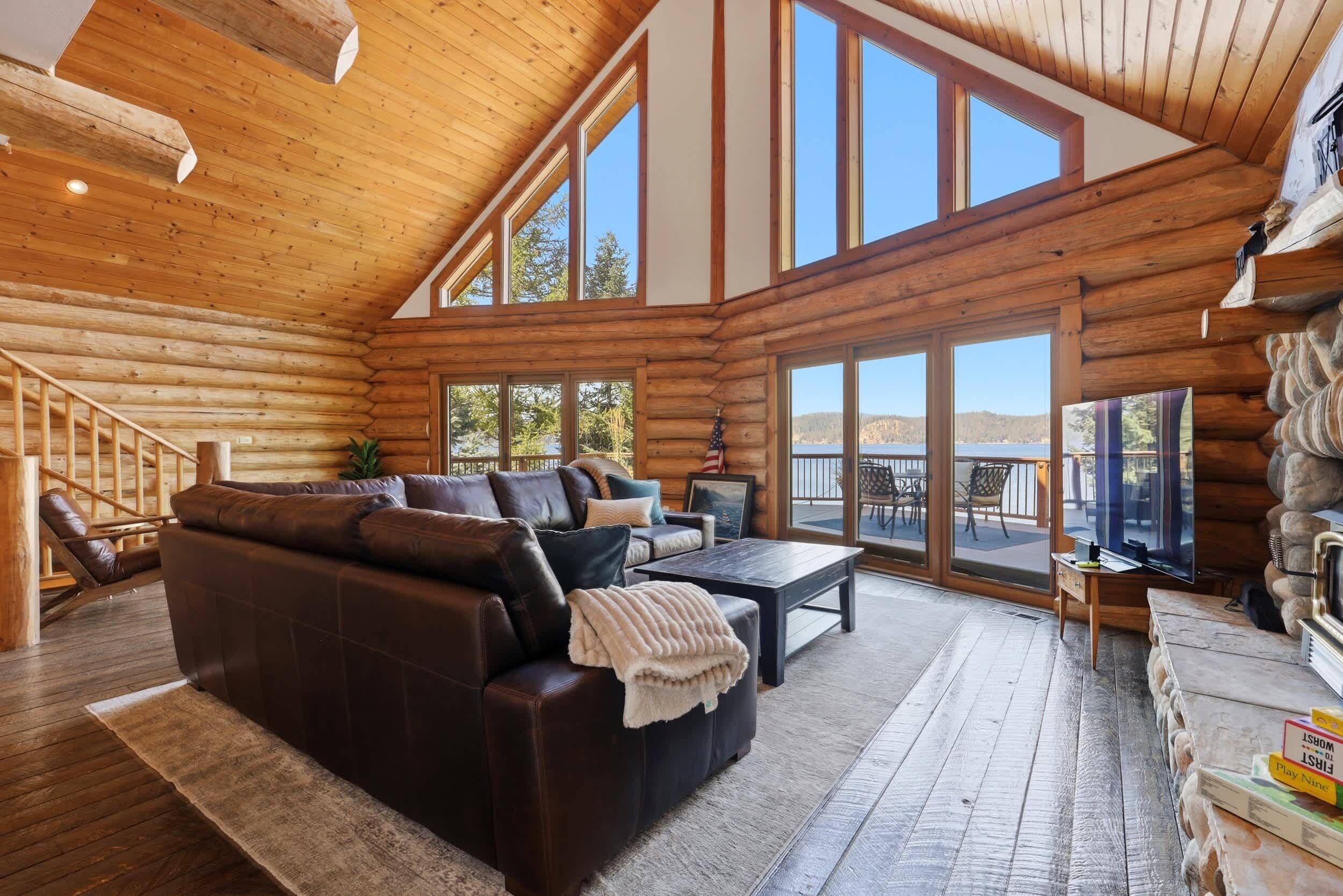 Ein rustikales Blockhaus-Interieur mit Ledersofa, Couchtisch und Fernseher.