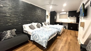 Una camera da letto con un letto, un divano, una scrivania e una televisione.
