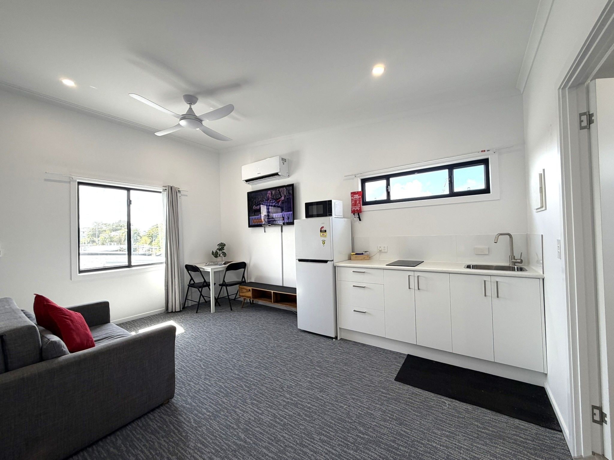 A compact living space with a kitchenette, a dining area, and a sofa.