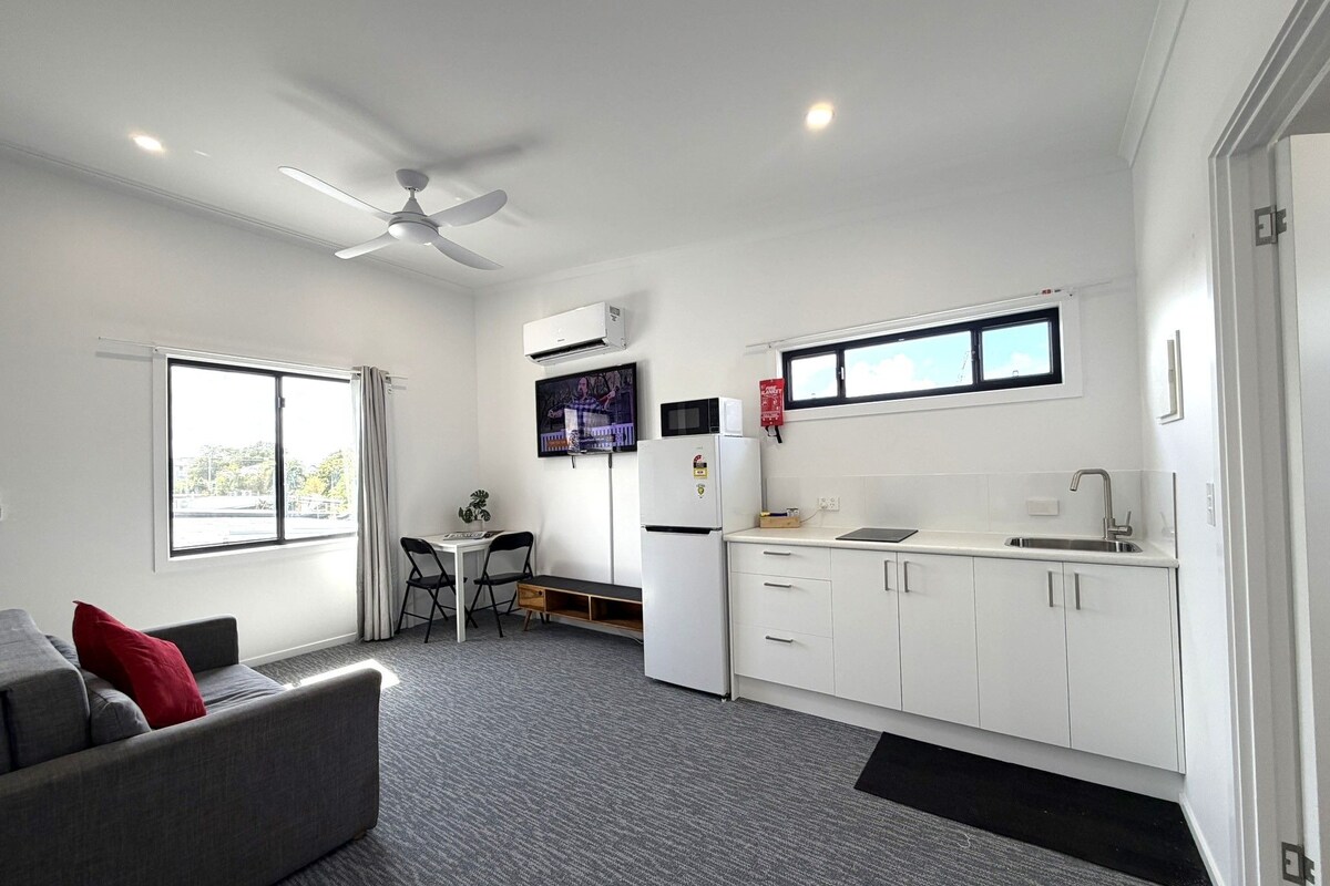 A compact living space with a kitchenette, a dining area, and a sofa.