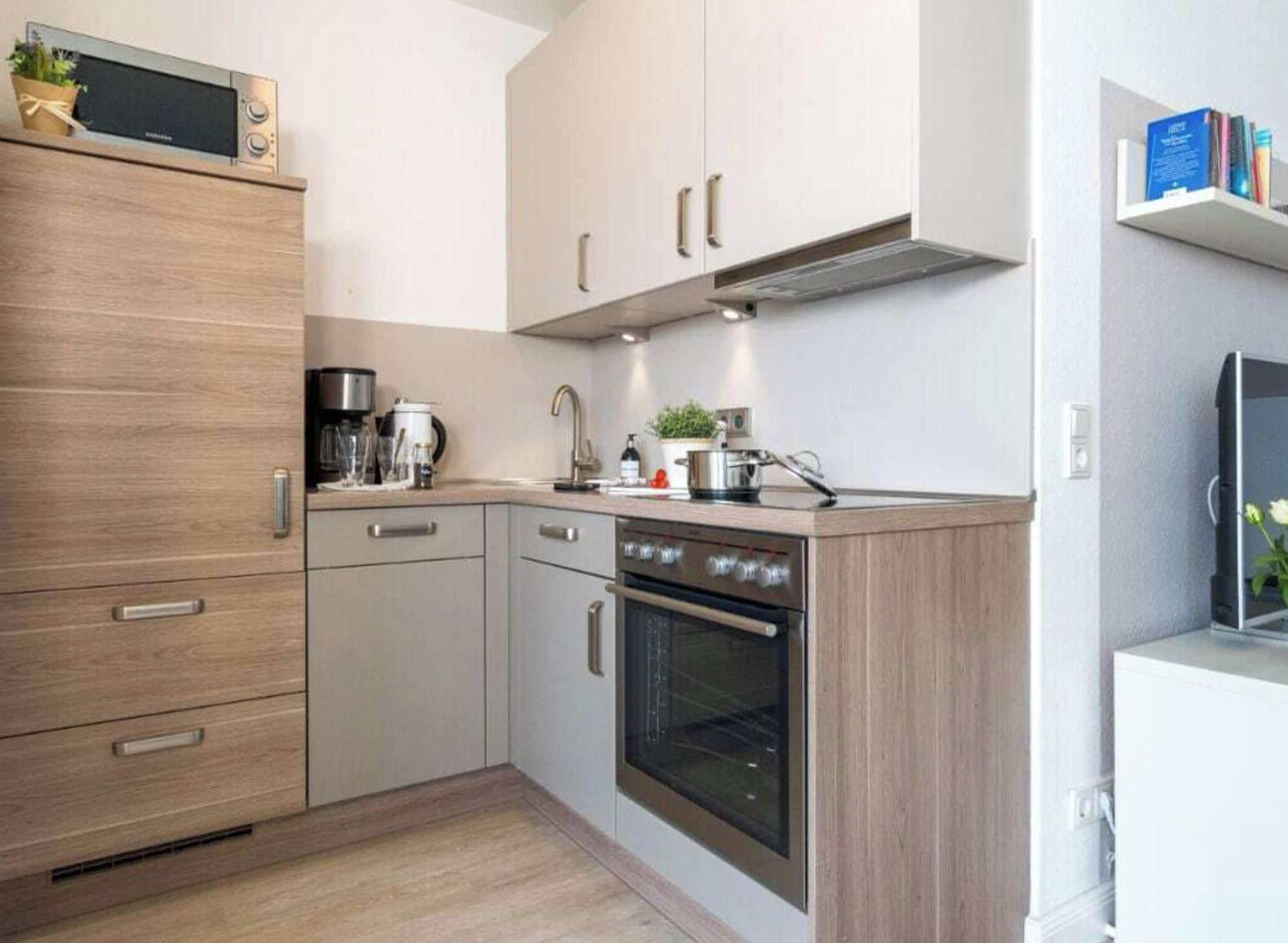 Eine moderne Küche mit Backofen, Kaffeemaschine und Mikrowelle.