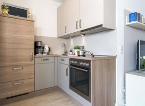 A modern kitchen with a built-in oven, a coffee maker, and a microwave. - Holiday Apartment With 2 Bedrooms (Heiligenhafen)