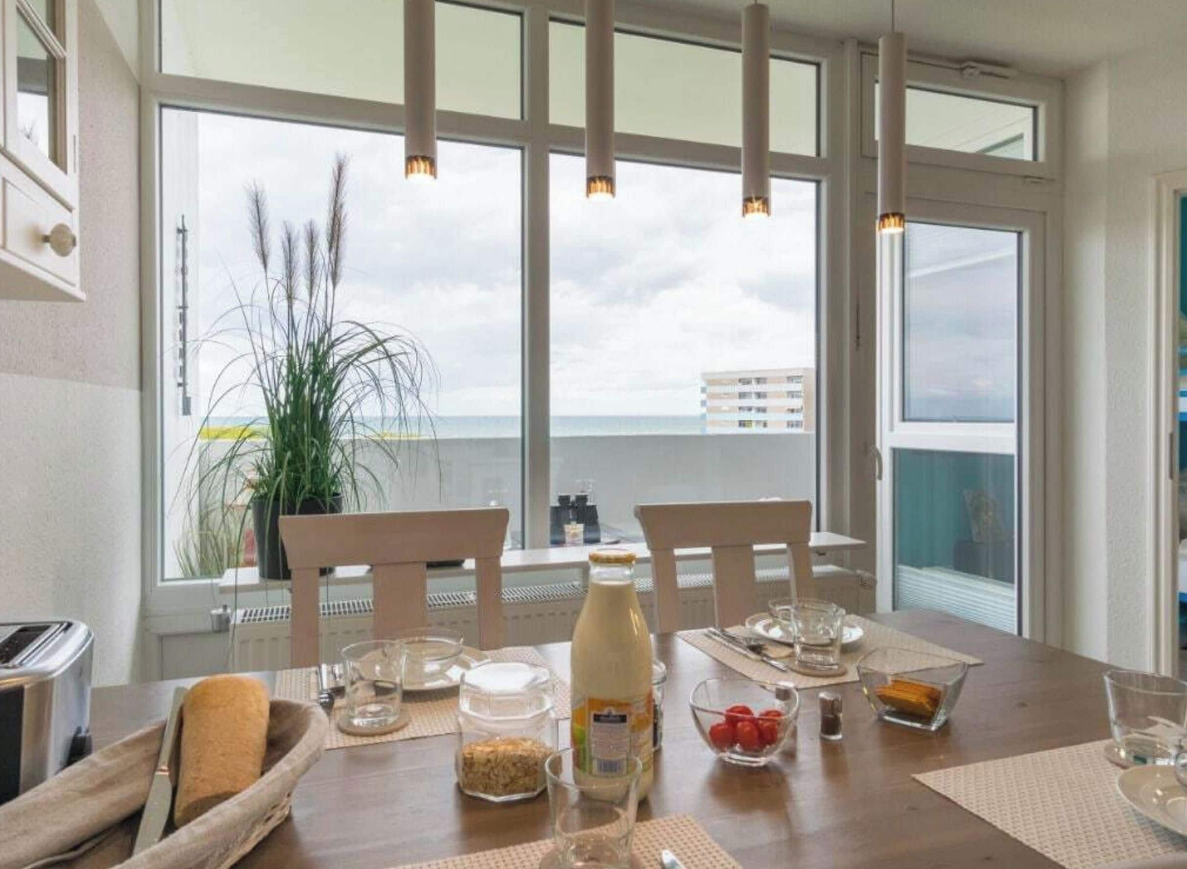 Een eettafel met stoelen, een fles melk en verschillende soorten eten.