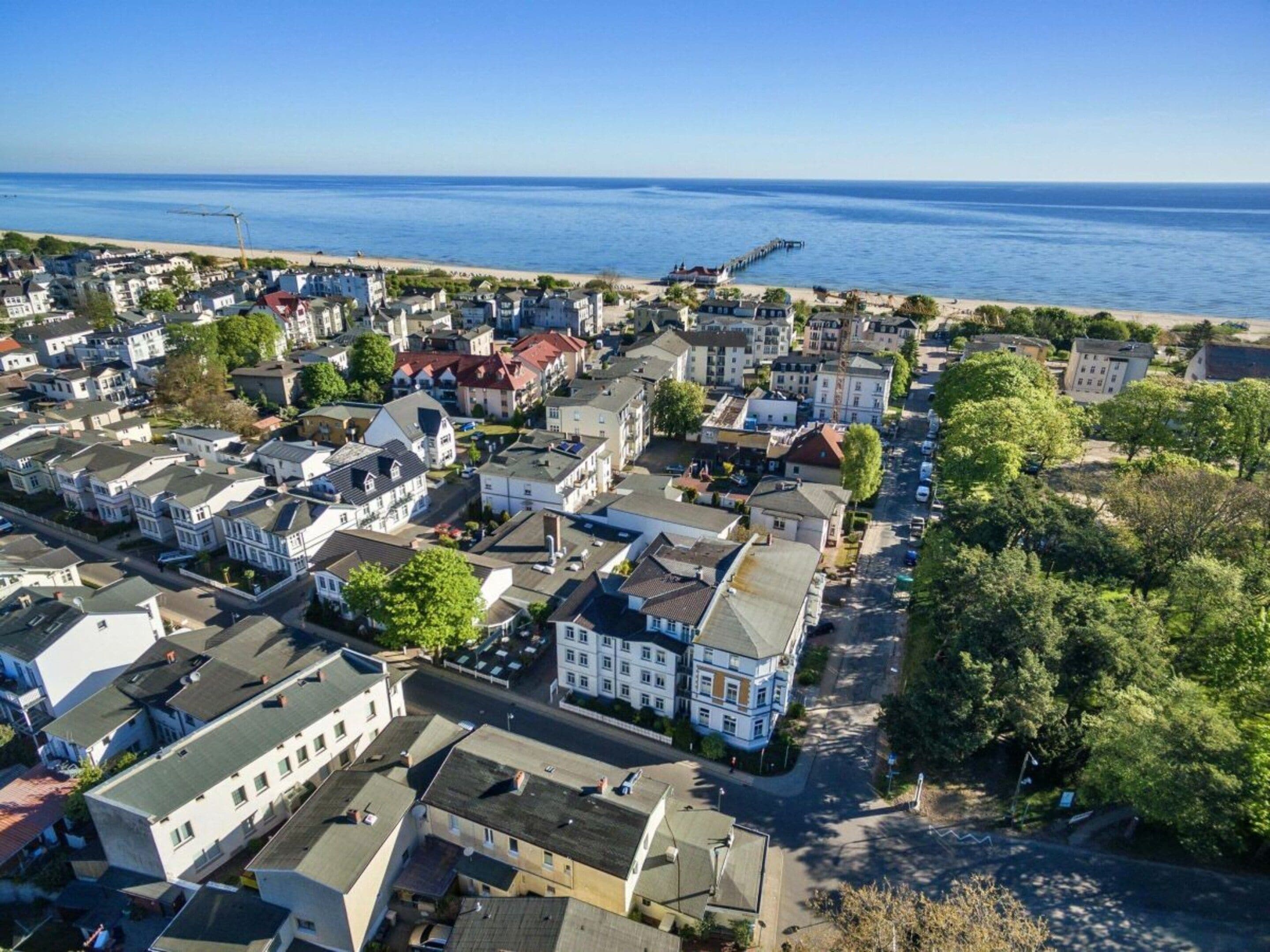 A coastal residential area with houses, a pier, and a beach.