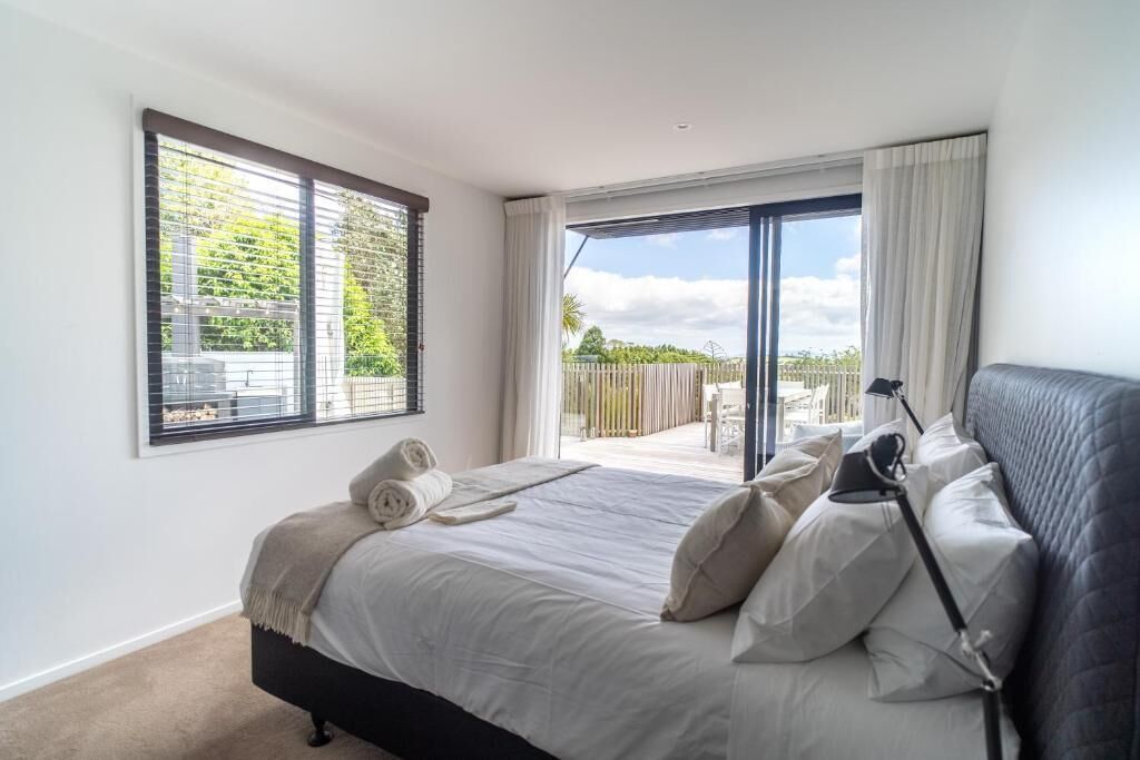 A bedroom with a bed, a window, and a view of the outdoors.