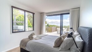 Un dormitorio con cama, ventana y vistas al exterior.