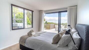 A bedroom with a bed, a window, and a view of the outdoors.