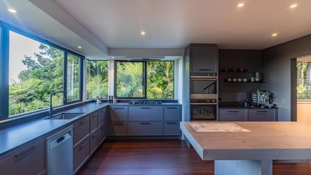 Una cocina moderna con lavavajillas integrado, estufa y cafetera.