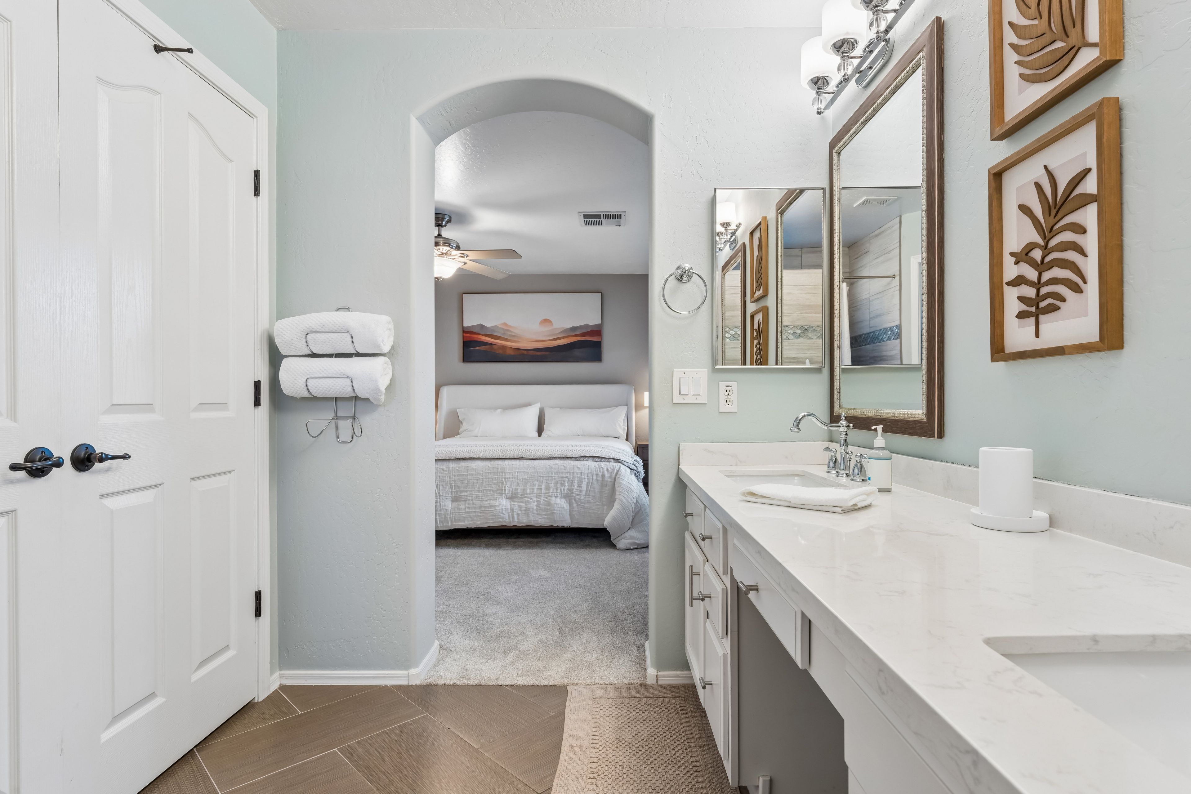 Une salle de bain moderne avec un grand miroir, un lavabo et une douche.