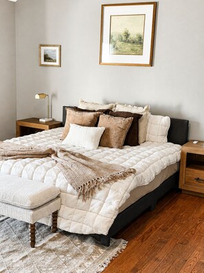 A bedroom with a bed, bedside tables, a lamp, a rug, and framed artwork on the wall. - Peaceful 4-bedroom house with AC in charming Shorewood (Shorewood)