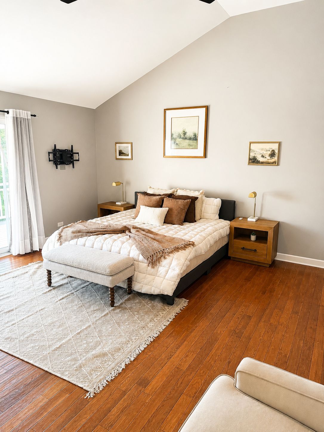A bedroom with a bed, bedside tables, a nightstand, a chair, and a window with curtains.