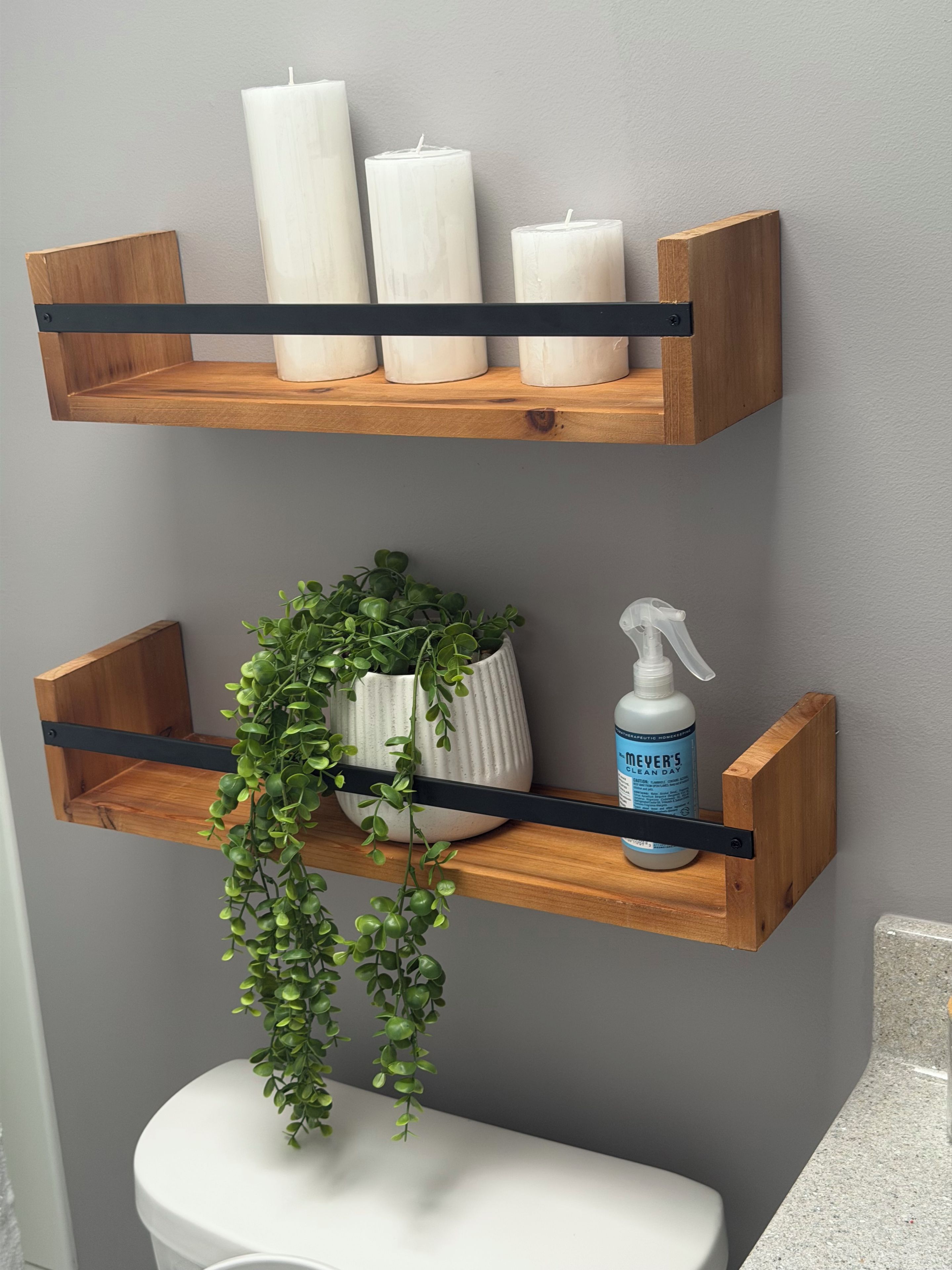 Ein Badezimmer mit Holzböden, Kerzen und einem Blumentopf.