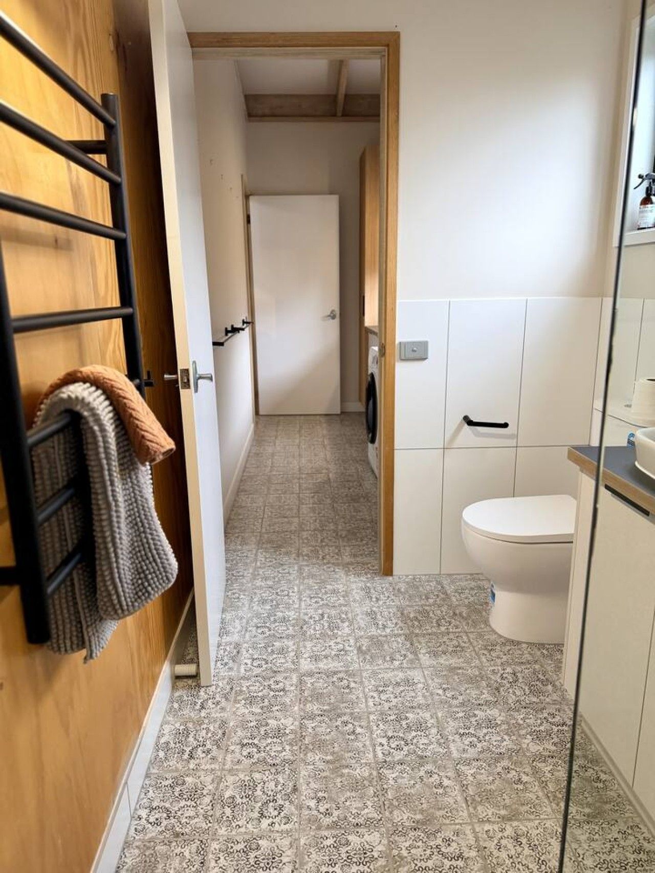 Et badeværelse med toilet, håndvask og bruseområde.