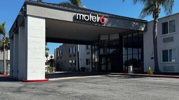 A motel with a modern design, featuring a covered entrance and large windows.