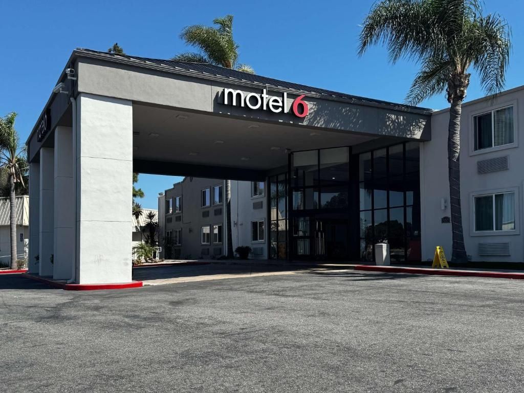 A motel with a modern design, featuring a covered entrance and large windows.