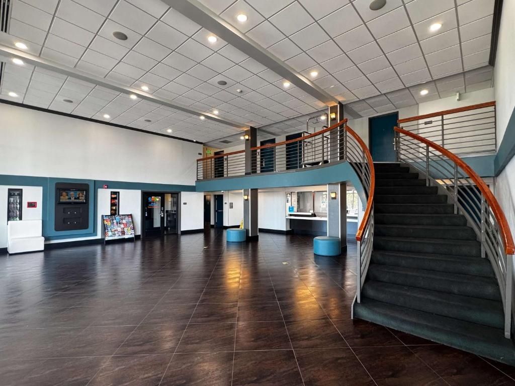Un hall d’entrée spacieux avec un escalier et un distributeur automatique.