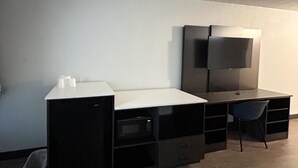 A compact, modern room with a built-in desk, a flat-screen TV, and a chair. - Old Town Room | 3 Budget-friendly Units | 1.5 Mi to Carson Town Center (Carson)