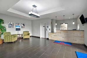 A hotel lobby with a reception desk, seating area, and a large plant. - 2 Family-Friendly Units | Longhorn Museum - 2.1 miles | Free Parking (Atascosa County)