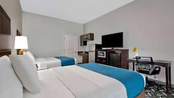 A hotel room with two beds, a desk with a chair, a television, and a kitchenette.