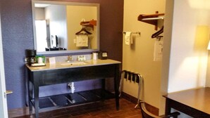 Ein Badezimmer mit Waschbecken, Spiegel, Handtuchhalter und einem Stuhl.