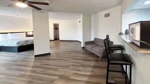 A hotel room with a bed, a ceiling fan, a kitchenette, and a seating area with a sofa and chairs. - Budget-Friendly Room | Free Parking, Pets Allowed | Durst Taylor Museum - 2.4 mi (Nacogdoches)