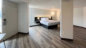 A bedroom with a bed, bedside tables, and a nightstand. - Budget & Pet-Friendly Room | Free Parking | Durst Taylor Museum - 2.4 miles (Nacogdoches)