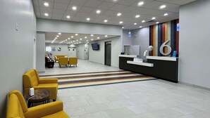 A reception area with a counter, a reception desk, and a seating area with yellow chairs. - 3 Budget-Friendly Rooms | 1.8 Miles to A. L. Mangham Jr. Airport (Nacogdoches)