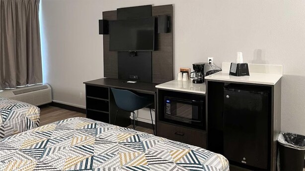 A hotel room with two beds, a desk, a chair, a TV, a microwave, and a coffee maker. - 4 Conveniently Located Rooms | A. L. Mangham Jr. Regional Airport (OCH) - 1.8 mi (Nacogdoches)