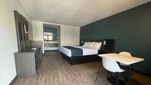 A bedroom with a bed, a desk, and a chair. There is a mirror on the wall and a door leading to another room. - Modern Room w/ Free Parking | Redondo Beach Station - 3 miles away (Gardena)