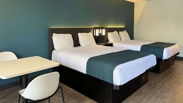 A hotel room with two beds, a small table, and a chair. - Value Stay | Room w/ Free Parking | 3 Miles from South Bay Galleria (Gardena)