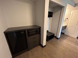 A compact room with a kitchenette, a microwave, and a small cabinet.
